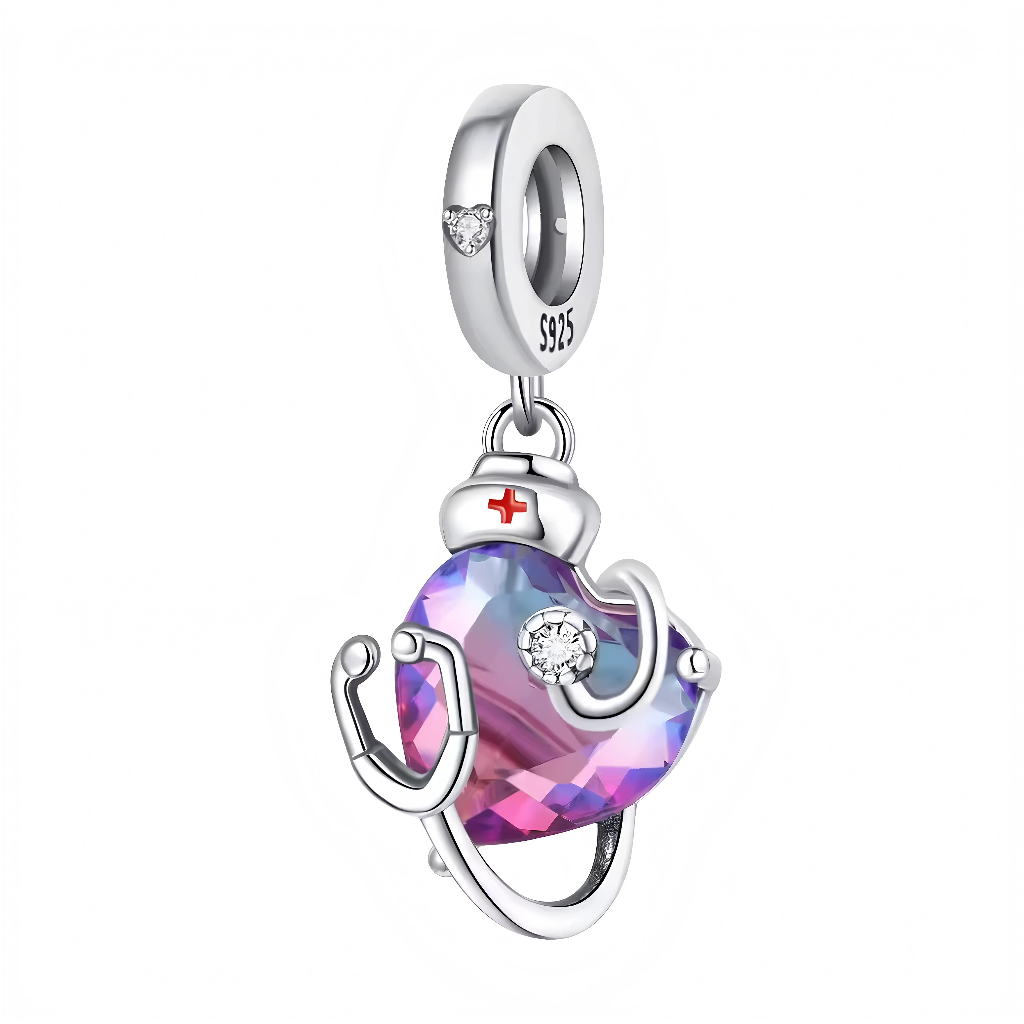Ce charm pendentif célèbre les soignants avec un cœur irisé violet en résine facettée, entouré d’un stéthoscope argenté formant un écrin protecteur, surmonté d’un bonnet rouge à croix blanche emblématique. Des zircons discrets illuminent le cœur et l’ensemble, apportant éclat et tendresse à ce symbole de soin. L’anneau supérieur rond facilite l’ajout gracieux sur les bracelets.