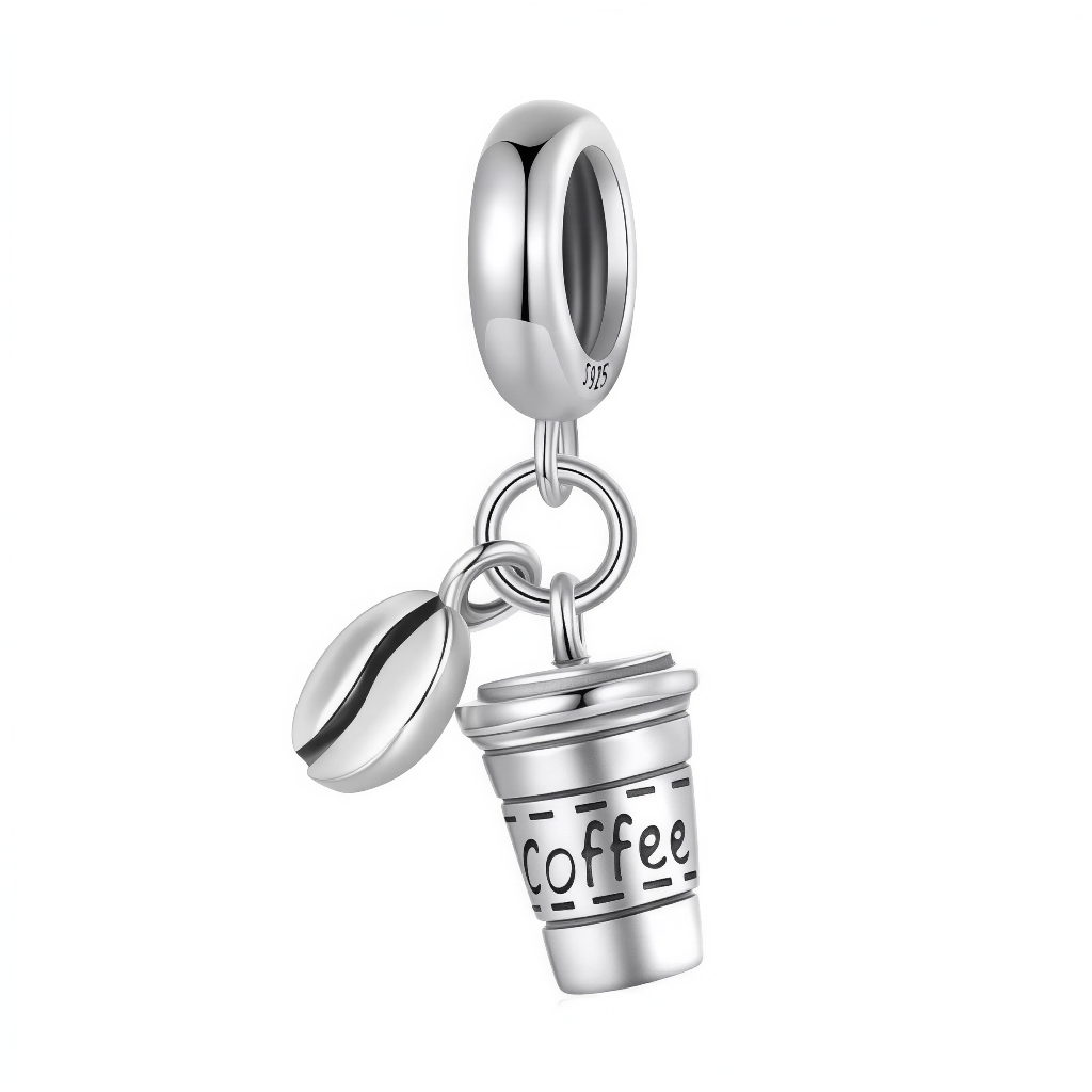 Ce charm pendentif recrée un moment cosy avec une tasse à café à emporter en argent sterling, gravée "COFFEE" en lettres stylées sur le côté, accompagnée d’un grain de café réaliste suspendu à côté. La tasse aux lignes droites et au manche discret évoque les pauses revigorantes du quotidien, tandis que le grain bombé ajoute une touche organique et gourmande. L’ensemble oscille légèrement au poignet, diffusant une invitation permanente à savourer un bon expresso.