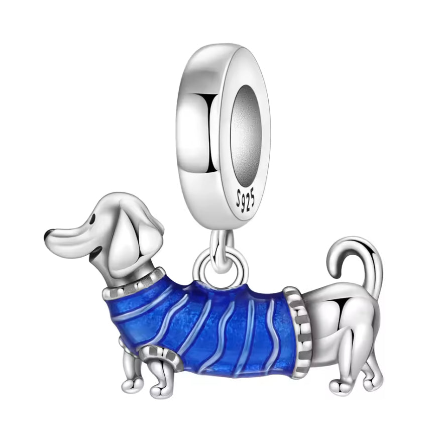 Ce charm plein de caractère met en scène un petit chien teckel, au corps long et aux pattes courtes, habillé d’un pull bleu texturé qui semble tout doux et bien chaud. La bélière lisse S925 assure une chute élégante sur le bracelet, tandis que les détails du museau, des oreilles et de la queue enroulée apportent une touche ultra craquante. Parfait pour les amoureux des chiens, et plus particulièrement des toutous « saucisse », ou pour ajouter une note fun à une composition de charms.