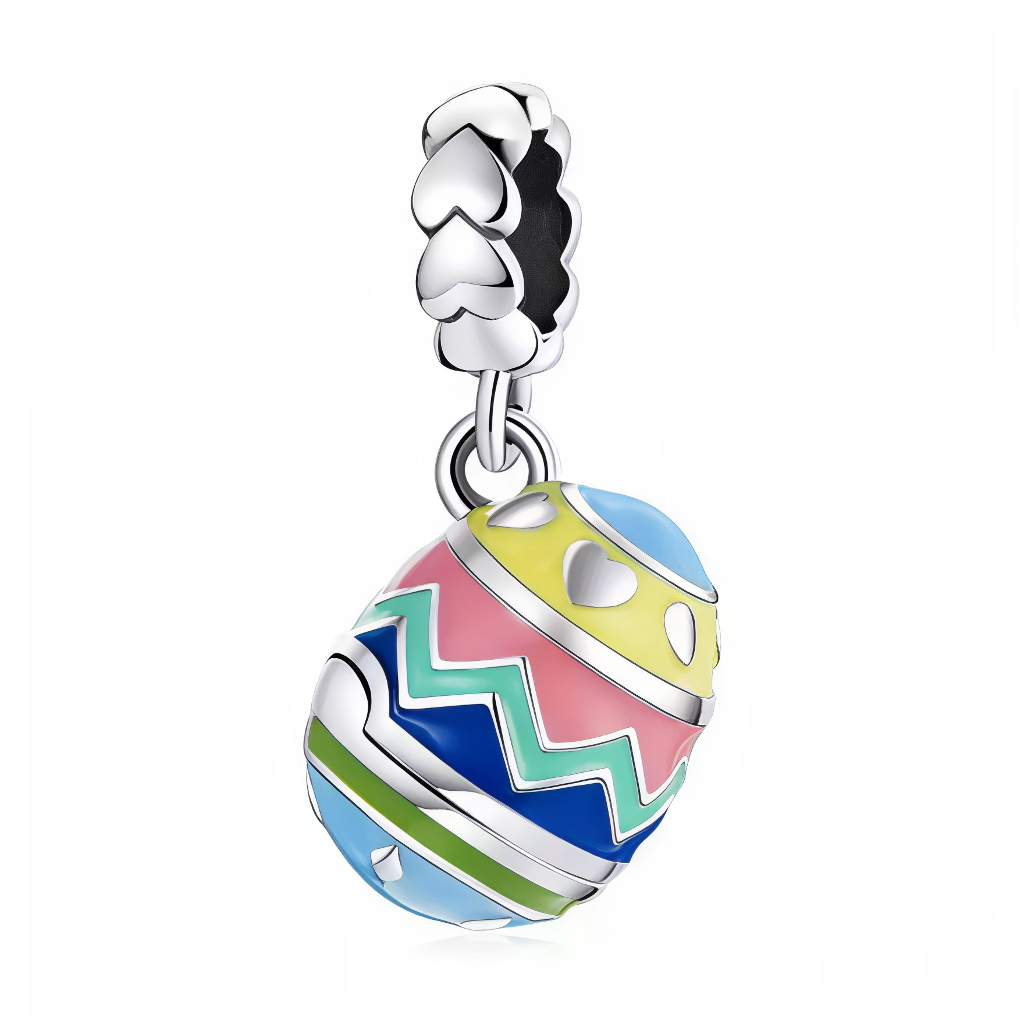 Ce charm pendentif arbore un œuf de Pâques ovale aux couleurs vives en émail, avec des motifs zigzag roses, bleus, jaunes et verts qui dansent joyeusement autour de la coquille. Des cœurs jaunes et blancs parsèment la surface, renforçant l’esprit festif et amoureux de la saison pascale. L’anneau supérieur en forme de cœur pavé de zircons clairs couronne cet objet printanier avec élégance.