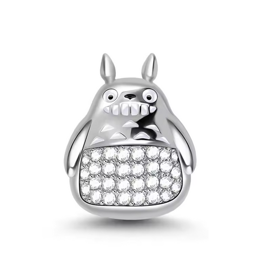 Ajoutez une touche de magie et de douceur à votre collection avec ce charm représentant Totoro, l'adorable esprit de la forêt du film culte Mon Voisin Totoro. Conçu en argent sterling S925, ce charm capture parfaitement la forme ronde et bienveillante de Totoro, avec ses grandes oreilles et son sourire apaisant.