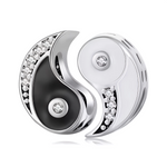 Ce charm pendentif emblématique arbore le symbole du Yin Yang en noir et blanc contrastés, avec un émail noir lustré d’un côté et un argent poli de l’autre, soulignant l’harmonie des opposés. Des zircons étincelants serti le long des courbes ondulées et au centre de chaque moitié ajoutent une brillance mystique et raffinée. L’anneau supérieur intégré permet une fixation fluide sur les bracelets à charms.