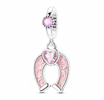 Ce charm en argent 925 se compose d’un anneau lisse serti d’un petit cristal rose rond, duquel pend un fer à cheval ajouré décoré d’émail rose pailleté. Au centre, en haut du fer à cheval, est serti un cœur facetté rose clair qui renforce le symbole de chance et d’amour.

Caractéristiques :

-Matière : Argent 925, émail rose pailleté et cristaux synthétiques roses.
-Design : Fer à cheval porte-bonheur orné de volutes émaillées et d’un cœur central facetté.
-Coloris : Argent brillant, rose tendre et éclats s