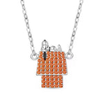 Ce collier capture la pose iconique de Snoopy, détendu sur sa maisonnette. Le toit et la façade sont entièrement pavés de pierres orange lumineuses qui apportent éclat et relief, tandis que Snoopy en argent poli crée un contraste élégant. Un bijou pop‑culture chic, parfait pour illuminer une tenue ou offrir à un fan des Peanuts.