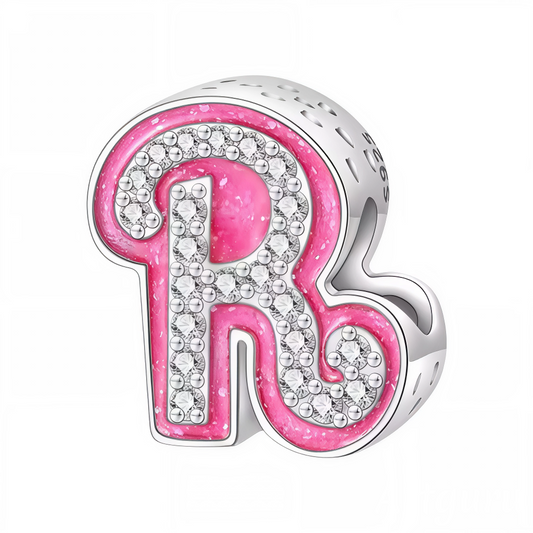 Apportez une touche glamour et fun à votre bracelet avec ce charm en forme de lettre "R", réalisé en argent 925 avec une finition rose brillante et orné de strass blancs scintillants. Un bijou tendance et pétillant, parfait pour afficher un style unique inspiré de l’univers Barbie, ou offrir un cadeau chic et coloré à un être cher.