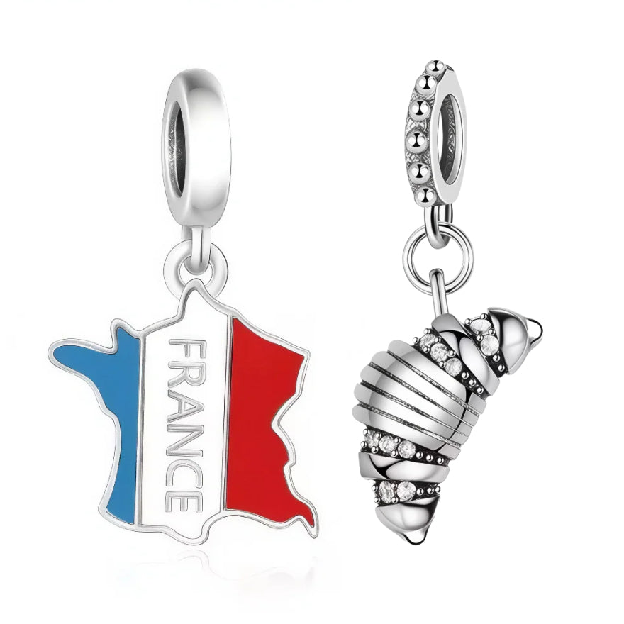 Affichez votre amour pour l’Hexagone avec ce duo de charms emblématiques réunissant la carte de France tricolore et un délicieux croissant bijou. En argent sterling 925, le pendentif France émaillé bleu-blanc-rouge célèbre fièrement la République, tandis que le charm croissant pavé de cristaux évoque les matins parisiens, la boulangerie du coin et l’art de vivre à la française.