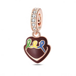 La bélière est plaquée or rose et sertie de zircons transparents qui apportent une touche très brillante et féminine. Le pendentif en forme de cœur chocolat est recouvert d’un glaçage brun, décoré d’un filet ondulé multicolore (vert, jaune, bleu) rappelant un coulis ou une écriture de pâtissier sur un gâteau. L’ensemble donne l’impression d’une mini pâtisserie luxueuse, idéale pour les amoureux de chocolat.