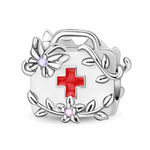 Ce charm en argent 925 représente un sac médical stylisé, orné en son centre d’une croix rouge brillante. Tout autour, des branches et feuilles en relief s’enroulent délicatement, ponctuées de deux petites fleurs dont le cœur est serti de pierres violettes et roses pour une touche de douceur.