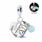 Ce charm pendentif en argent 925 réunit trois breloques symboliques : un chapeau de diplômé, un carnet gravé « Planning - Thinking - Idea » décoré de petits cristaux colorés, et une ampoule lumineuse bleu pâle qui brille dans le noir. L’anneau supérieur est orné d’un cœur discret et d’un cristal bleu, pour une finition élégante.