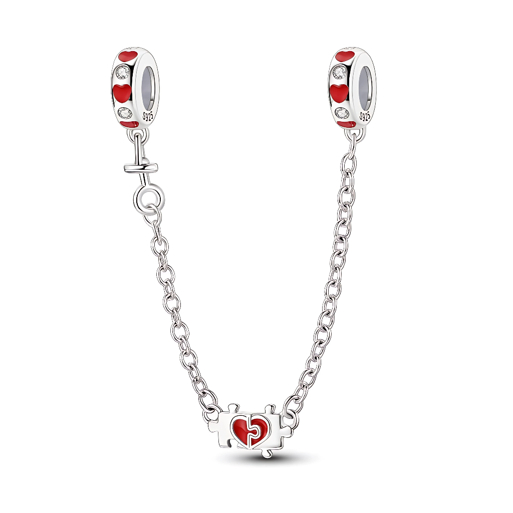 Cette chaîne de sécurité en argent 925 est ornée de deux bélières décorées de petits cœurs rouges émaillés et de zircons clairs, qui apportent une touche romantique tout autour du bracelet. Au centre de la chaîne, un petit pendentif en forme de pièce de puzzle renferme un cœur rouge, symbole de deux âmes qui s’emboîtent parfaitement.