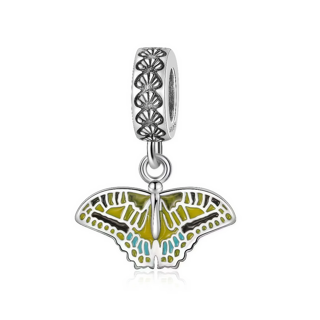 Ce charm pendant en&nbsp;argent&nbsp;925 représente un papillon aux ailes largement déployées, suspendu à une bélière finement ajourée de motifs floraux. Les ailes sont remplies d’émail dans des tons vert olive et turquoise, qui contrastent avec le contour argenté pour un rendu très naturel.