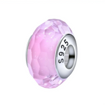 Ce charm en&nbsp;verre&nbsp;de Murano rose facetté est monté sur une âme en argent 925 gravée “S925”, créant une perle lumineuse et scintillante idéale pour adoucir un bracelet.