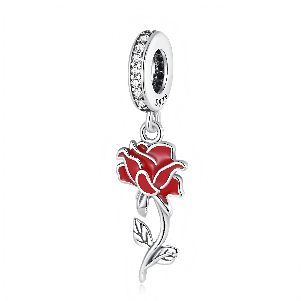 Ce charm pendentif en argent 925 représente une élégante rose rouge stylisée, dont les pétales sont recouverts d’un émail rouge profond souligné par des contours argentés pour un effet raffiné. La tige longue et légèrement courbée, ornée de petites feuilles délicates, se balance sous une bélière pavée de zirconias clairs.