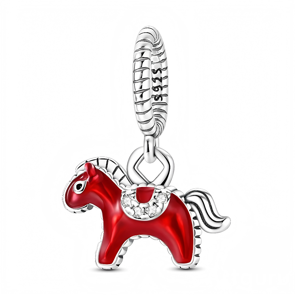 Ce charm pendentif en argent représente un petit cheval stylisé recouvert d’un émail rouge brillant, avec une crinière et une queue striées argentées. Son harnachement est orné de petits zirconias clairs qui ajoutent une touche lumineuse et festive.
