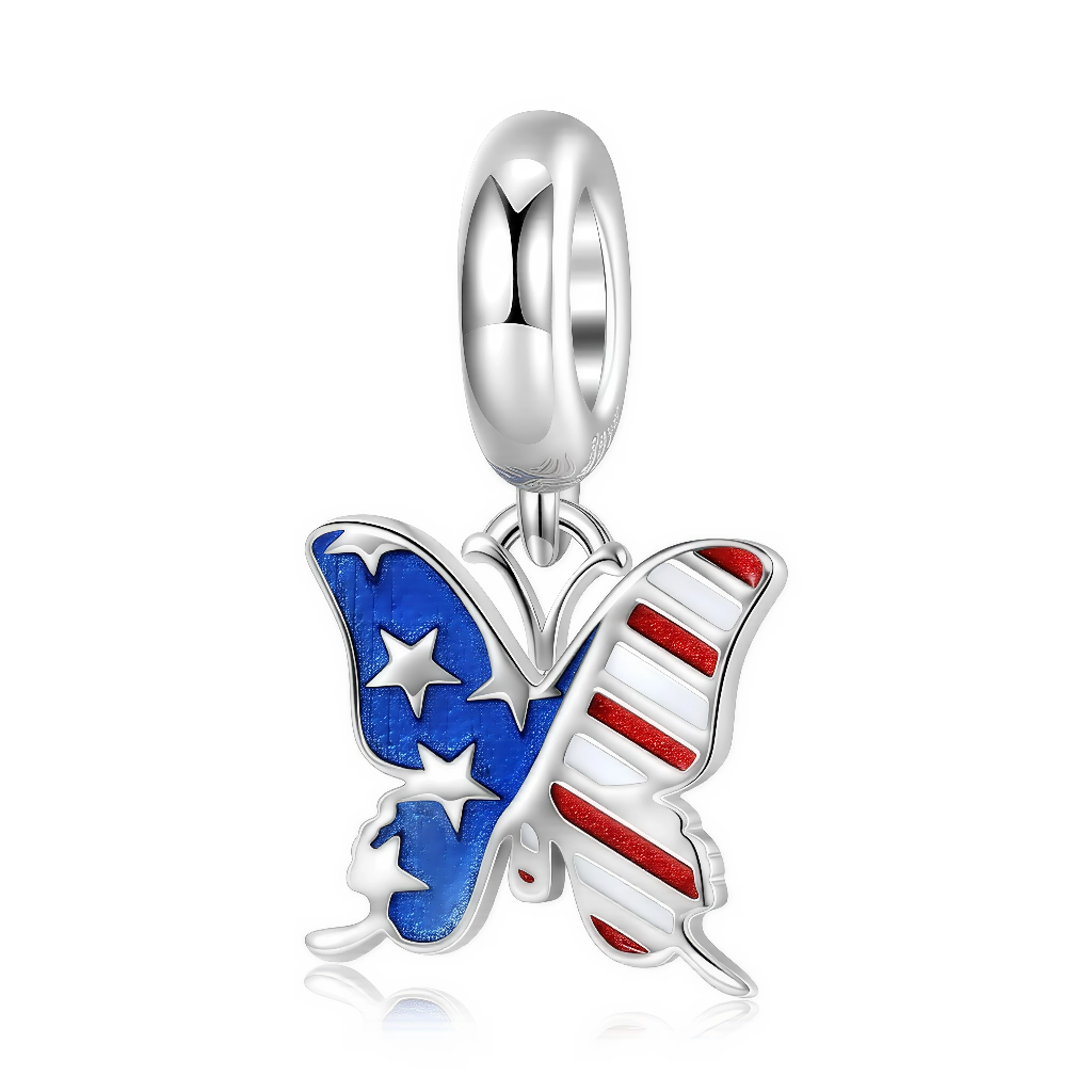 Ce charm pendentif en argent 925 représente un papillon stylisé dont les ailes sont décorées comme un drapeau américain, avec un côté bleu nuit parsemé d’étoiles blanches et l’autre orné de rayures rouges et blanches en émail brillant. Le papillon est suspendu à une bélière lisse, pour un rendu épuré qui met en valeur les couleurs vives patriotiques.